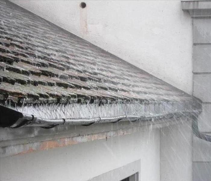 A roof has a leak in it, causing heavy rains to enter the home and cause water damage.