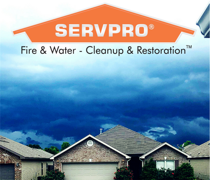 houses with dark skies overhead and SERVPRO logo at the top